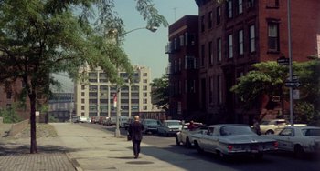 Movie still from “The Landlord” (1970), directed by Hal Ashby – A man walking down a street past parked cars; Extreme Wide shot, High angle