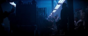 Movie still from “The Last Boy Scout” (1991), directed by Tony Scott – A group of people sitting in a dark room; Wide shot, Low angle