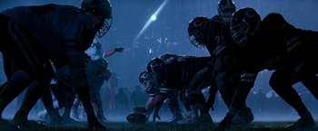 Movie still from “The Last Boy Scout” (1991), directed by Tony Scott – A group of football players are playing a game in the rain; Wide shot, Low angle