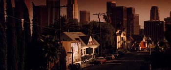 Movie still from “The Last Boy Scout” (1991), directed by Tony Scott – A street scene with a building and some cars parked on the side of the road; Extreme Wide shot, Low angle