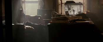 Movie still from “The Last Boy Scout” (1991), directed by Tony Scott – A person sitting on a chair in a room; Wide shot, Over the shoulder angle