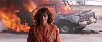 Movie still from “The Last Boy Scout” (1991), directed by Tony Scott – A woman standing in front of a burning car; Close Up shot, Low angle