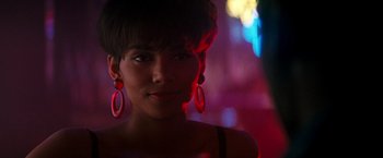 Movie still from “The Last Boy Scout” (1991), directed by Tony Scott – A young woman wearing red earrings in a dark room; Close Up shot, Over the shoulder angle