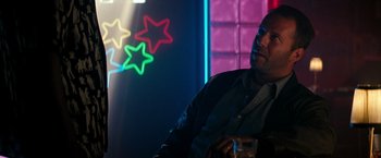 Movie still from “The Last Boy Scout” (1991), directed by Tony Scott – A man sitting in front of a neon sign; Close Up shot, Over the shoulder angle