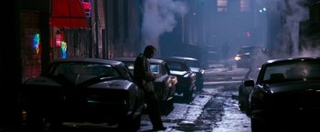 Movie still from “The Last Boy Scout” (1991), directed by Tony Scott – A man walking down a street next to parked cars at night; Wide shot, High angle