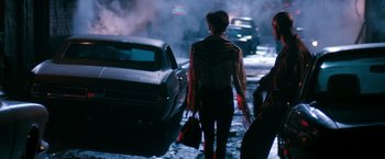 Movie still from “The Last Boy Scout” (1991), directed by Tony Scott – A woman walking down a street holding a purse; Wide shot, Low angle