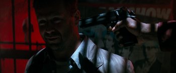 Movie still from “The Last Boy Scout” (1991), directed by Tony Scott – A man holding a gun up to his face; Close Up shot, Low angle