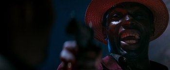 Movie still from “The Last Boy Scout” (1991), directed by Tony Scott – A man in a red hat is holding a gun; Close Up shot, Low angle