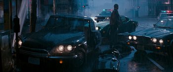 Movie still from “The Last Boy Scout” (1991), directed by Tony Scott – A man standing next to a car on a street; Wide shot, High angle
