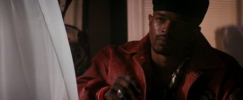 Movie still from “The Last Boy Scout” (1991), directed by Tony Scott – A man in a red jacket is looking at a laptop; Close Up shot, Low angle