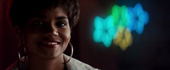 Movie still from “The Last Boy Scout” (1991), directed by Tony Scott – A person smiling with a blurry background; Close Up shot, Over the shoulder angle