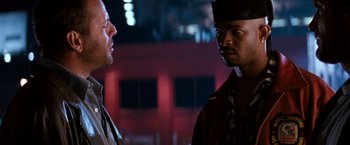 Movie still from “The Last Boy Scout” (1991), directed by Tony Scott – Two men standing next to each other in front of a building; Close Up shot, Over the shoulder angle