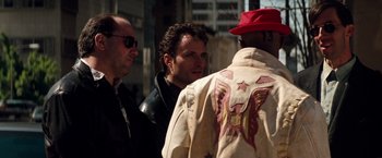 Movie still from “The Last Boy Scout” (1991), directed by Tony Scott – A group of men standing next to each other on the street; Medium shot, Over the shoulder angle