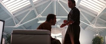 Movie still from “The Last Boy Scout” (1991), directed by Tony Scott – Two men are talking and one is smoking a cigarette; Medium shot, Low angle