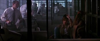 Movie still from “The Last Boy Scout” (1991), directed by Tony Scott – A woman sitting on the floor of a train station; Wide shot, Over the shoulder angle