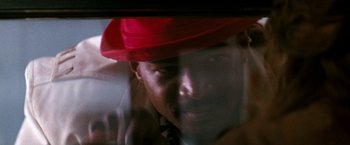 Movie still from “The Last Boy Scout” (1991), directed by Tony Scott – A man wearing a red hat looking out a window; Extreme Close Up shot, Low angle