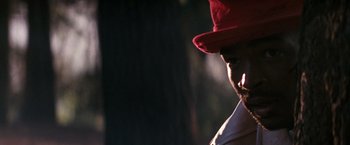 Movie still from “The Last Boy Scout” (1991), directed by Tony Scott – A man wearing a red hat and a white shirt; Close Up shot, Over the shoulder angle