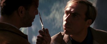 Movie still from “The Last Boy Scout” (1991), directed by Tony Scott – A man holding a pair of scissors up to his face; Close Up shot, Over the shoulder angle