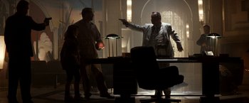 Movie still from “The Last Boy Scout” (1991), directed by Tony Scott – A man pointing a gun at another man in a room; Medium shot, Low angle