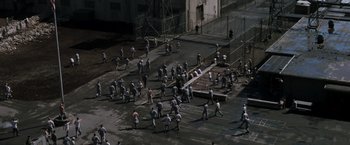 Movie still from “The Last Castle” (2001), directed by Rod Lurie – An aerial view of a group of people walking across a street; Extreme Wide shot, High angle