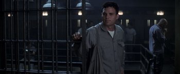 Movie still from “The Last Castle” (2001), directed by Rod Lurie – A man standing in a jail cell behind bars; Medium shot, Over the shoulder angle