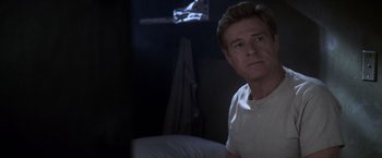 Movie still from “The Last Castle” (2001), directed by Rod Lurie – A person sitting on a bed in a dark room; Close Up shot, Over the shoulder angle