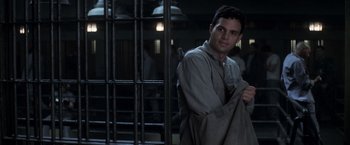 Movie still from “The Last Castle” (2001), directed by Rod Lurie – A man holding a towel standing in front of a jail cell; Medium shot, Over the shoulder angle