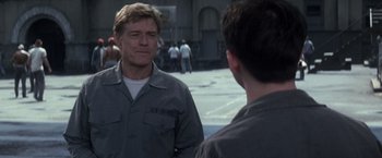 Movie still from “The Last Castle” (2001), directed by Rod Lurie – Two men are talking on the street in front of a crowd; Medium shot, Over the shoulder angle