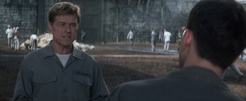 Movie still from “The Last Castle” (2001), directed by Rod Lurie – A group of men playing a game of baseball in a field; Close Up shot, Over the shoulder angle