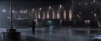 Movie still from “The Last Castle” (2001), directed by Rod Lurie – A person standing in a dark room with a building in the background; Extreme Wide shot, High angle
