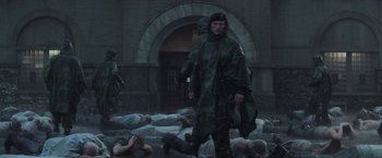 Movie still from “The Last Castle” (2001), directed by Rod Lurie – A man standing in front of a bunch of corpses; Wide shot, High angle
