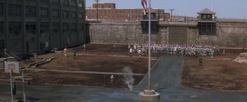 Movie still from “The Last Castle” (2001), directed by Rod Lurie – A group of people standing in a field with a fire hydrant on the ground; Extreme Wide shot, High angle