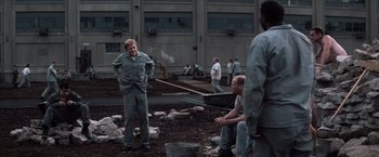 Movie still from “The Last Castle” (2001), directed by Rod Lurie – A group of men standing around in a field; Wide shot, Over the shoulder angle