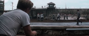 Movie still from “The Last Castle” (2001), directed by Rod Lurie – A group of baseball players playing baseball in a field; Wide shot, Over the shoulder angle