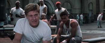 Movie still from “The Last Castle” (2001), directed by Rod Lurie – A group of men sitting next to each other on a dock; Medium shot, Over the shoulder angle