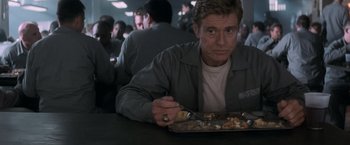 Movie still from “The Last Castle” (2001), directed by Rod Lurie – A man sitting at a table with a plate of food; Close Up shot, Over the shoulder angle