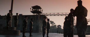 Movie still from “The Last Castle” (2001), directed by Rod Lurie – A group of men standing next to each other in front of a building; Extreme Wide shot, Low angle