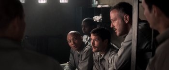 Movie still from “The Last Castle” (2001), directed by Rod Lurie – A group of men sitting next to each other in a room; Medium shot, Over the shoulder angle