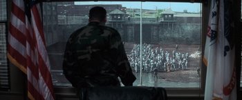 Movie still from “The Last Castle” (2001), directed by Rod Lurie – A man in military fatigues looking out of a window; Extreme Wide shot, High angle