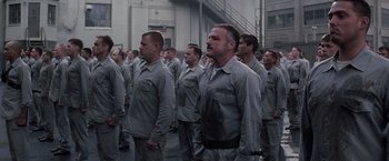 Movie still from “The Last Castle” (2001), directed by Rod Lurie – A group of men standing next to each other in grey uniforms; Medium shot, High angle