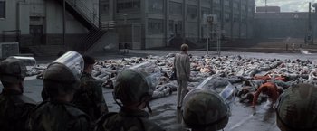 Movie still from “The Last Castle” (2001), directed by Rod Lurie – A group of people laying on the ground in the street; Wide shot, High angle