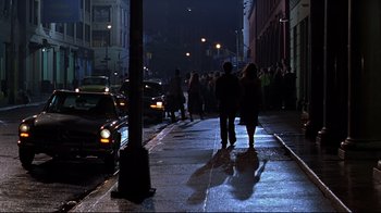 Movie still from “The Last Days of Disco” (1998), directed by Whit Stillman – A group of people walking down a sidewalk at night; Wide shot, Over the shoulder angle