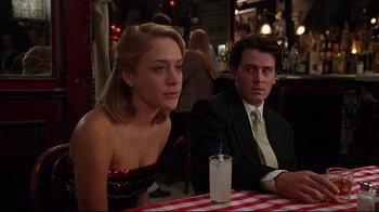 Movie still from “The Last Days of Disco” (1998), directed by Whit Stillman – A man and a woman sitting at a table with a drink; Medium shot, Over the shoulder angle