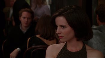 Movie still from “The Last Days of Disco” (1998), directed by Whit Stillman – A woman sitting in front of a group of people in a room; Close Up shot, Over the shoulder angle