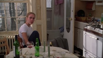 Movie still from “The Last Days of Disco” (1998), directed by Whit Stillman – A woman sitting at a table with a glass of red wine; Medium shot, Over the shoulder angle