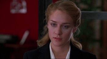 Movie still from “The Last Days of Disco” (1998), directed by Whit Stillman – A woman with blonde hair wearing a black suit; Close Up shot, Over the shoulder angle