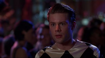 Movie still from “The Last Days of Disco” (1998), directed by Whit Stillman – A man in a black and white shirt is looking to his left; Close Up shot, Over the shoulder angle