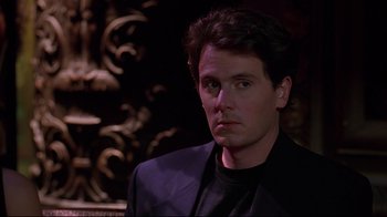 Movie still from “The Last Days of Disco” (1998), directed by Whit Stillman – A person wearing a suit and tie; Close Up shot, Over the shoulder angle