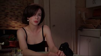 Movie still from “The Last Days of Disco” (1998), directed by Whit Stillman – A woman sitting at a dining table in a room; Close Up shot, Over the shoulder angle