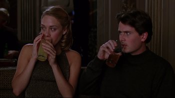 Movie still from “The Last Days of Disco” (1998), directed by Whit Stillman – A man and a woman are drinking a drink together; Medium shot, Over the shoulder angle
